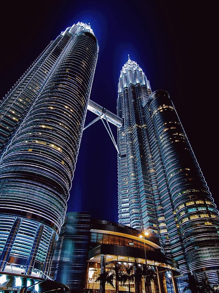 Stunning nighttime view of the illuminated Petronas Towers in Kuala Lumpur, Malaysia.